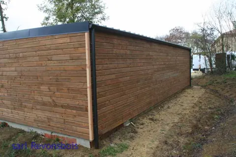 Long garage toit plat lasuré brun, vue latérale